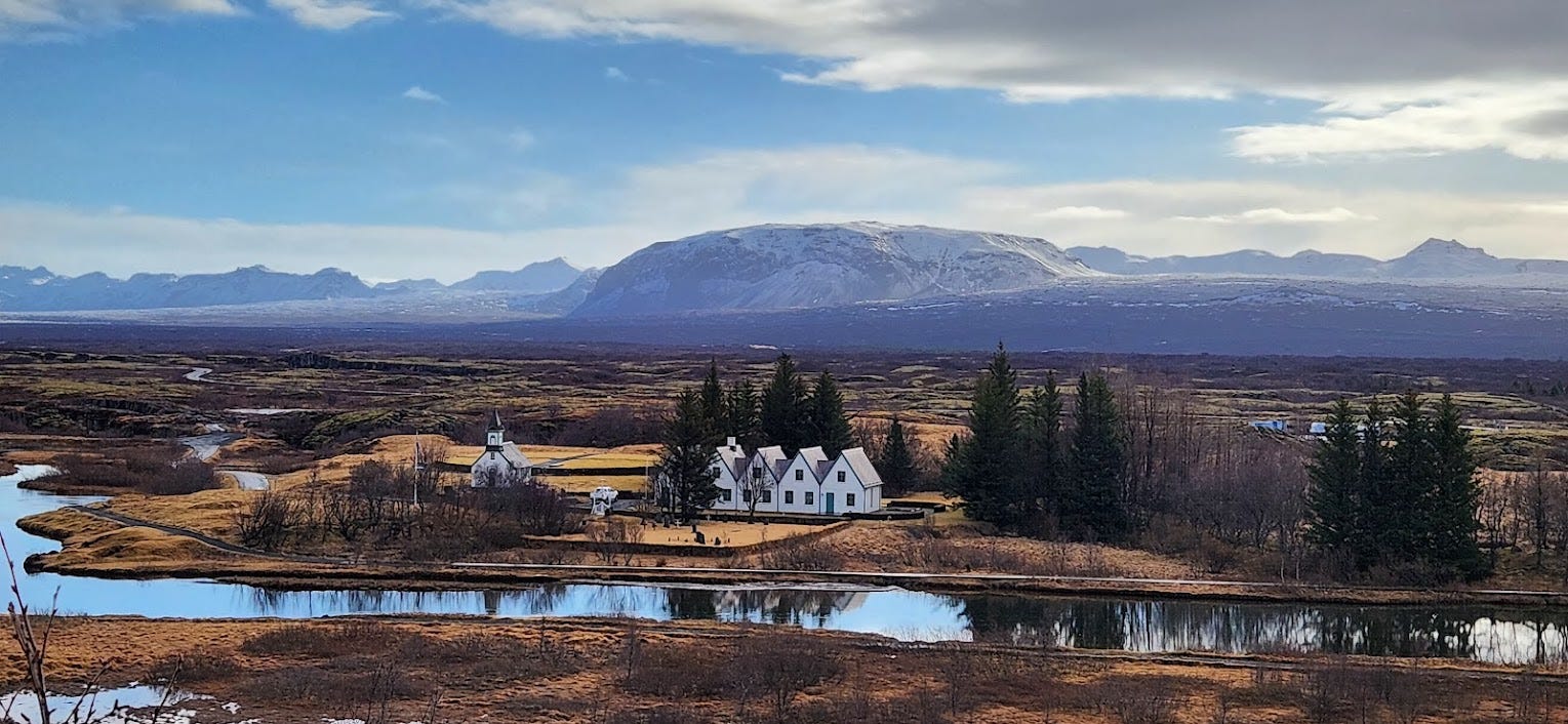 View over a river to a church in a meadow in Iceland